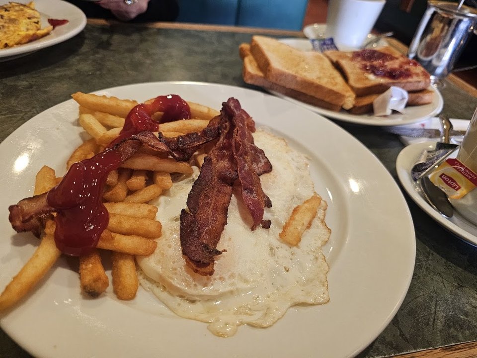 Coffee beside a breakfast plate.